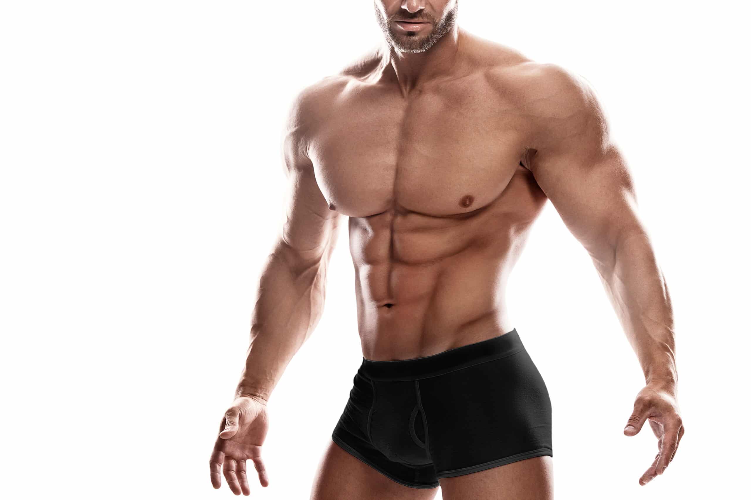 Muscular man wearing black underwear posing against white backgr